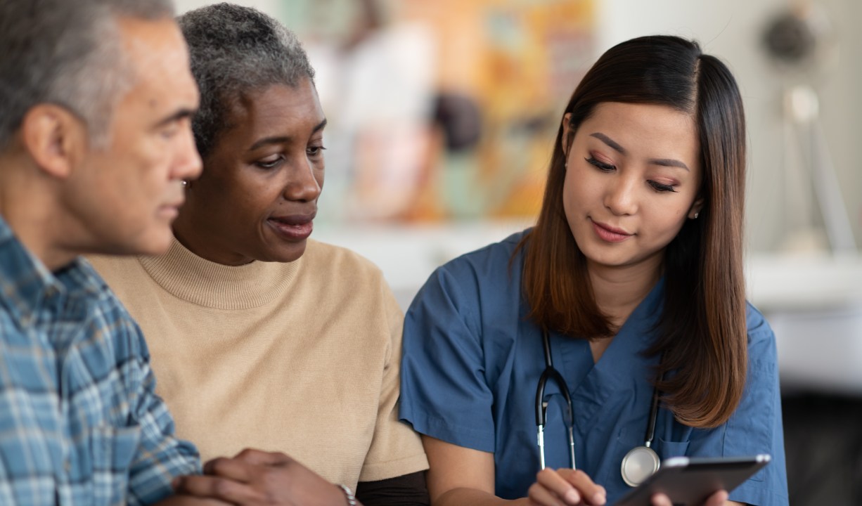 two senior adults reviewing health care information with a provider