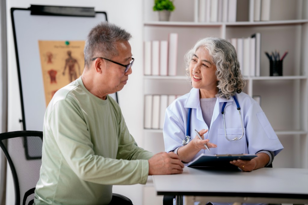 Female doctor listening symptom of senior patient and taking notes